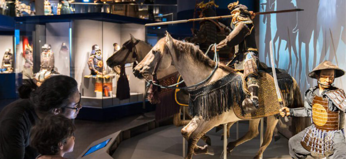 Besucher im Samurai Museum Berlin vor einer Samurai-Rüstung zu Pferd