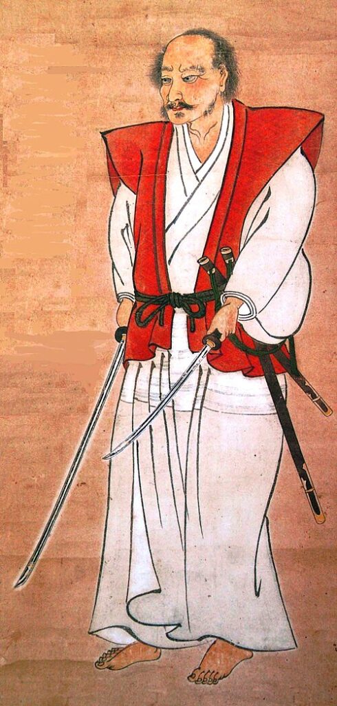 Historical portrait of Musashi in white robe with red haori, sword drawn