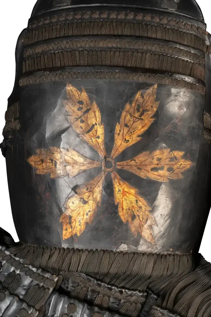 Armor detail of a cuirass with gold six-petaled mon crest on black lacquer